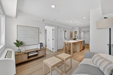 Calgary apartment for rent - A living room with a grey couch and wooden furniture.