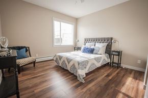 Edmonton apartment for rent - A bedroom with a large bed and a chair.