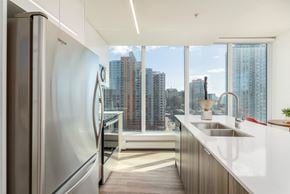 Calgary apartment for rent - A modern kitchen with a stainless steel refrigerator and a view of the city.