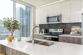 Calgary apartment for rent - A modern kitchen with a large window overlooking the city.