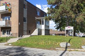 Orangeville apartment for rent - a large brick building with a sign in front of it