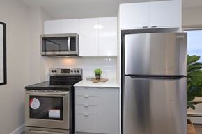 Orangeville apartment for rent - a small kitchen with white cabinets and stainless steel appliances