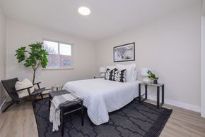 Orangeville apartment for rent - a bedroom with a large bed and a chair in a 555 waverly unit