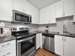 Orillia apartment for rent - a kitchen with white cabinets and stainless steel appliances