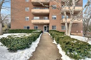 Aurora apartment for rent - a brick apartment building with balconies and snow on the ground