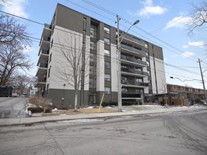 Toronto apartment for rent - an image of a grey and white apartment building with a street light in front of it