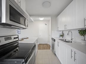 Toronto apartment for rent - a kitchen with white cabinetry and black appliances