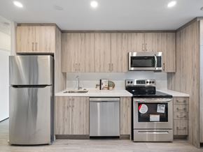 Toronto apartment for rent - A modern kitchen with a refrigerator, microwave, oven, and sink.