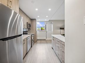 Toronto apartment for rent - A modern kitchen with a refrigerator on the left and a counter on the right.