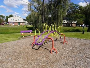Taylor townhouse for rent - A playground with a purple and yellow structure and a red bench.