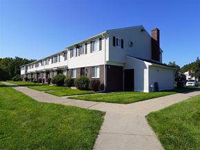Taylor apartment for rent - A white building with a brown roof and a garage door.