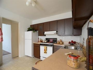 Taylor apartment for rent - A kitchen with brown cabinets and a white fridge.