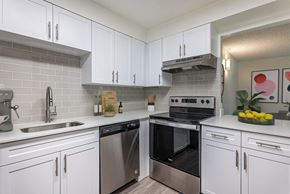 Northglenn apartment for rent - A modern kitchen with white cabinets and stainless steel appliances.