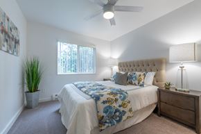 Tigard apartment for rent - a bedroom with a large bed and a ceiling fan