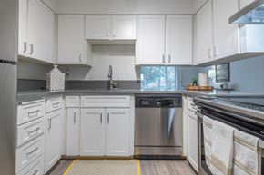 Tigard apartment for rent - a kitchen with white cabinets and stainless steel appliances