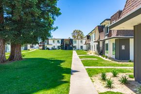 Rancho Cordova apartment for rent - a row of houses on a grassy area with trees in the background