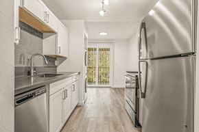 Beaverton apartment for rent - a kitchen with white cabinets and stainless steel appliances