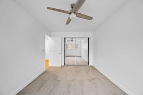 Beaverton apartment for rent - a bedroom with a ceiling fan and a door to a hallway