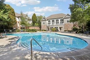Jonesboro apartment for rent - A swimming pool in front of a house with a brick wall.