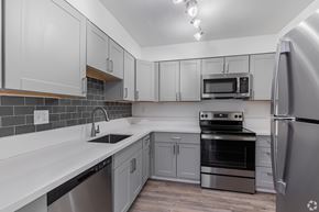 Beaverton apartment for rent - A kitchen with a stainless steel refrigerator, oven, and microwave.