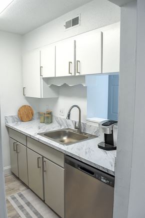 Charleston apartment for rent - a kitchen with white cabinets and a stainless steel sink