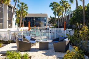 Orlando apartment for rent - an outdoor patio with chairs and tables next to a pool