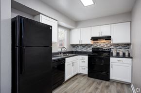 Orlando apartment for rent - an empty kitchen with black appliances and white cabinets