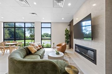 Miami apartment for rent - A modern living room with a green couch and a flat screen TV mounted on the wall.