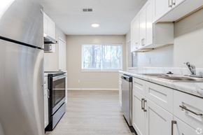 Austell apartment for rent - A kitchen with white cabinets and a black fridge.