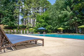 Austell apartment for rent - A pool surrounded by trees and umbrellas.