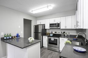Beaverton apartment for rent - a kitchen with white cabinets and stainless steel appliances