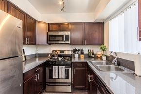 Culver City apartment for rent - a kitchen with dark wood cabinets and stainless steel appliances