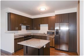 Portland apartment for rent - a kitchen with dark wood cabinets and granite countertops