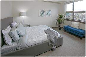 Portland apartment for rent - a bedroom with a large bed and a blue chaise lounge