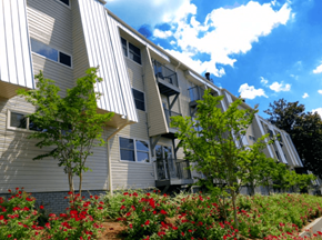 Birmingham apartment for rent - A building with a grey facade and red flowers in front.