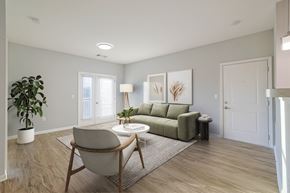Knoxville apartment for rent - A living room with a green couch, a chair, and a potted plant.