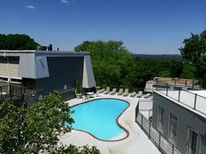 Birmingham apartment for rent - A swimming pool surrounded by trees and buildings.