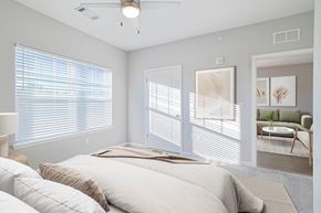 Knoxville apartment for rent - A bedroom with a large bed and a window with blinds.