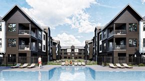 Knoxville apartment for rent - A person is standing by the pool in front of apartment buildings.