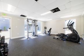 Birmingham apartment for rent - A spacious gym with a variety of equipment including treadmills, stationary bikes, and a weight machine.