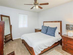 Chattanooga apartment for rent - A bedroom with a bed, dresser, and mirror.