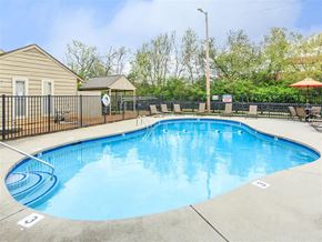 Knoxville apartment for rent - a resort style pool with chairs and a fence around it