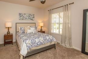 Chattanooga apartment for rent - A bedroom with a bed, two lamps, and a painting on the wall.