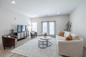 Norton Shores apartment for rent - A living room with a brown chair, a white couch, and a rug.