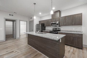 Norton Shores apartment for rent - A modern kitchen with a granite countertop and wooden cabinets.