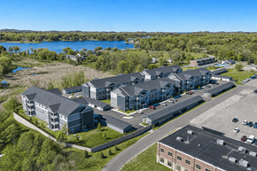 Norton Shores apartment for rent - A large building complex with a parking lot in front.