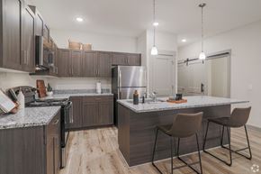 Allendale Charter Twp apartment for rent - A modern kitchen with a large island and bar stools.