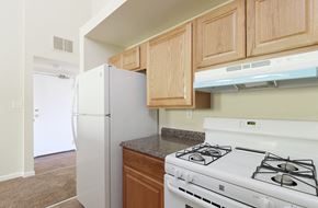 Baltimore apartment for rent - a kitchen with white appliances and wooden cabinets