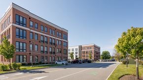 Newton apartment for rent - A red brick building with a white car parked in front.