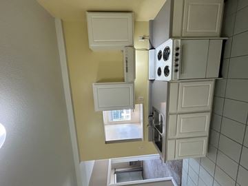 Groton apartment for rent - A kitchen with white cabinets and a window.